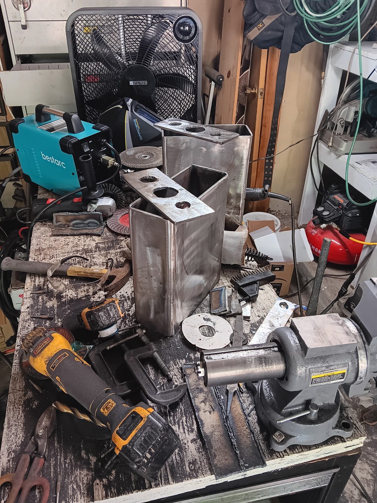 Fabrication in progress on the workbench — welder, grinder, vise