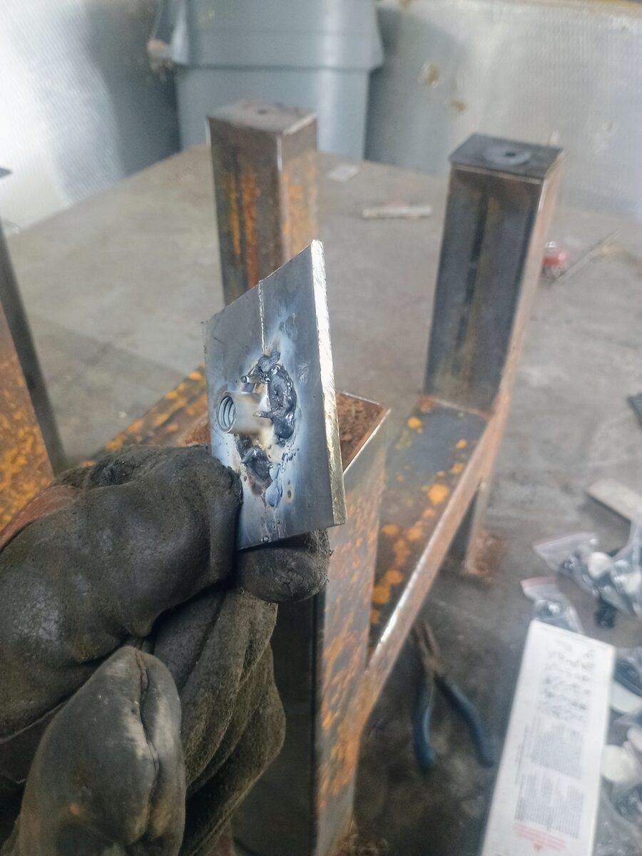 Nut plate detail — a threaded bolt welded into a steel plate for the leveling foot