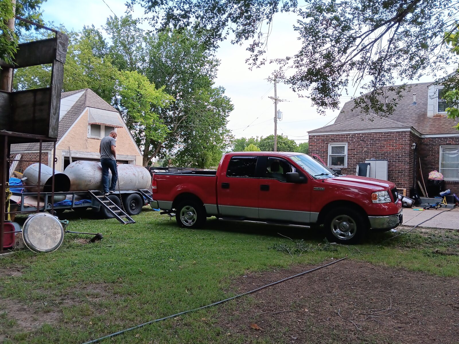 Truck backing up to the tank on the trailer — gantry frame visible in the background